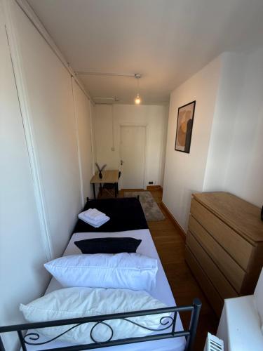 a small room with two beds and a table at Charming Stay House in Ealing