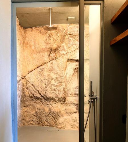 a stone wall in a bathroom with a glass door at Casa Avella Mountain Retreat in Pennapiedimonte