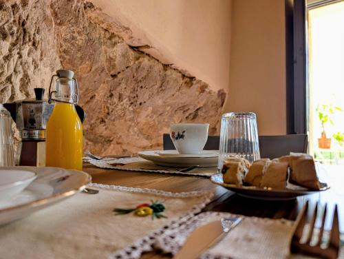 a table with a plate of food and a bottle of orange juice at Casa Avella Mountain Retreat in Pennapiedimonte