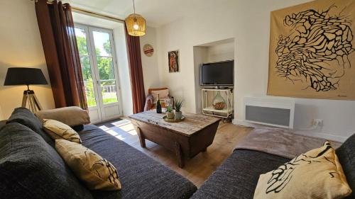 a living room with a couch and a coffee table at Gîte Lou Clapas in Salles-la-Source