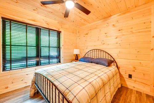 a bedroom with a bed in a log cabin at Near Mammoth Cave Family-Friendly Cabin with Patio! in Cave City