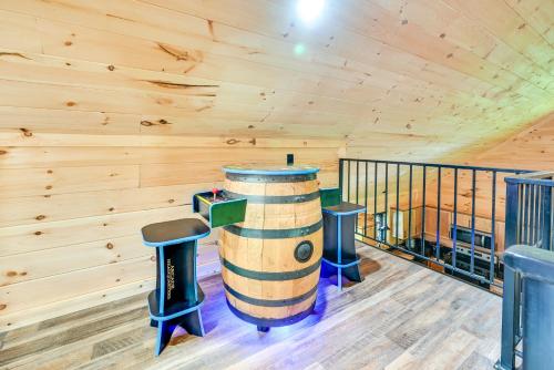 a log cabin with a wine barrel and stools at Near Mammoth Cave Family-Friendly Cabin with Patio! in Cave City
