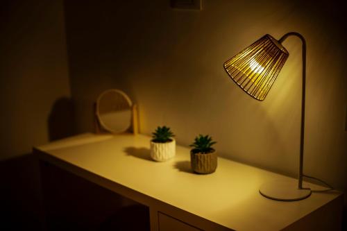 a desk with a lamp and two plants on it at Casa Alagna - La Casetta al Mare con Idromassaggio in Palermo
