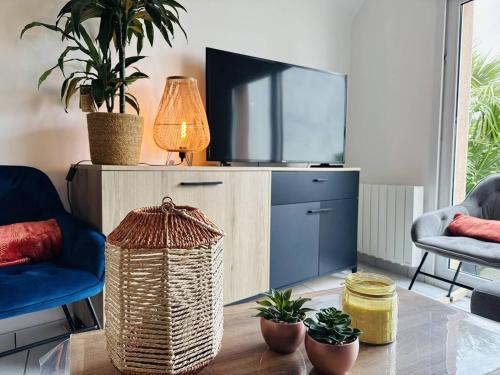 un salon avec une télévision et une table dans l'établissement Ty Marie Galante, 2 chambres, plage et commerces à pied, parking, à Quiberon