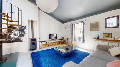 - un salon avec un canapé et un tapis bleu dans l'établissement Charming Loft Apartment by Canal Saint Martin, à Paris