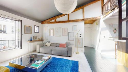 un salon avec un canapé et une table dans l'établissement Charming Loft Apartment by Canal Saint Martin, à Paris