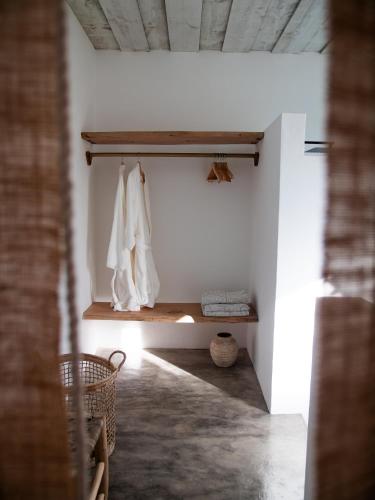a room with white walls and a shelf with towels at Casa Thala - Conceptual 3-Suite Villa & Hot Pool in Alcácer do Sal