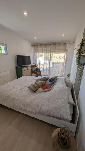 a large bed in a bedroom with a window at Appartement cosy avec jardin in Meauzac