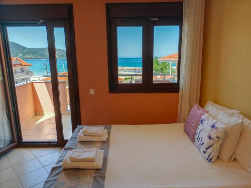 a bedroom with a bed with a view of the ocean at Lavender Apartments in Skala Potamias