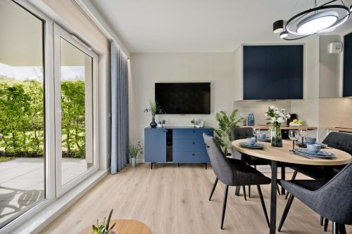 a kitchen and dining room with a table and chairs at BlueApart Apartamenty Na Klifie in Władysławowo