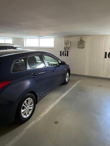 a blue car parked in a parking garage at A large 1 bedroom apartment with an available private parking in Prague