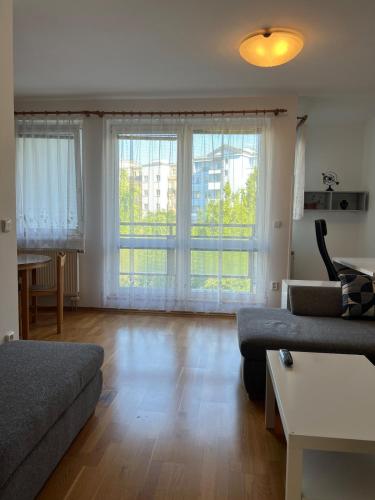 a living room with a couch and two windows at A large 1 bedroom apartment with an available private parking in Prague