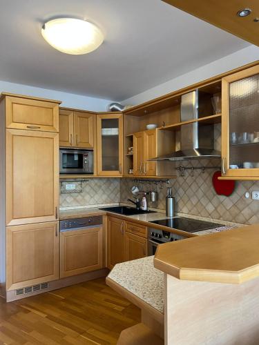 a kitchen with wooden cabinets and a counter top at A large 1 bedroom apartment with an available private parking in Prague