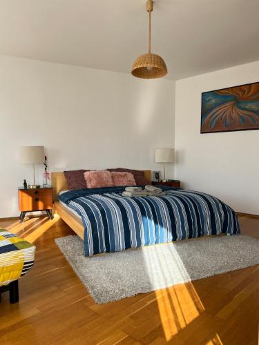 a bedroom with a bed with a striped comforter at A large 1 bedroom apartment with an available private parking in Prague