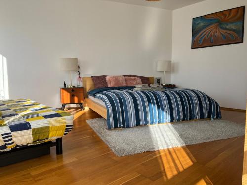 a bedroom with a bed and a rug on a wooden floor at A large 1 bedroom apartment with an available private parking in Prague