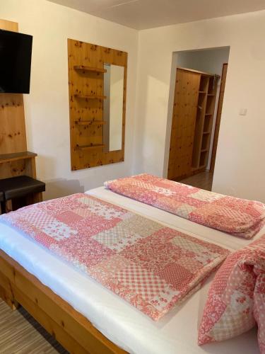 two beds in a room with a mirror and cabinets at Gasthaus Schöberingerhof in Weyregg
