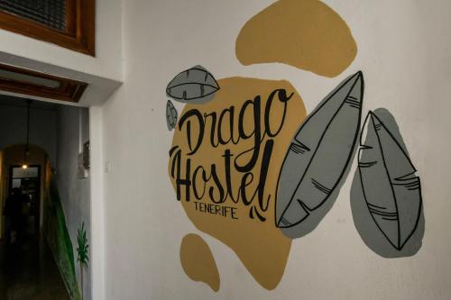 a sign on a wall with surfboards on it at Drago Hostel in Icod de los Vinos