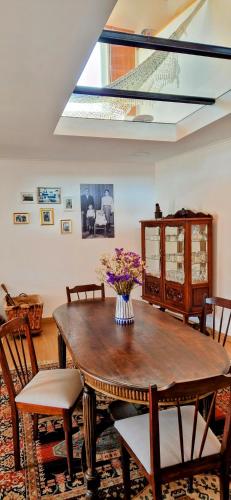 a dining room with a wooden table and chairs at Casas Cor de Rosa in São Martinho das Moitas