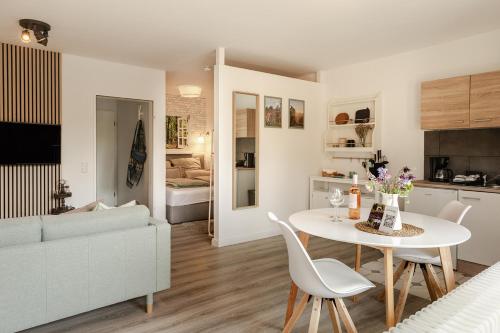 a kitchen and living room with a table and a couch at HeideHygge 3 in Schneverdingen