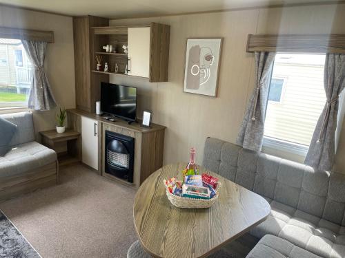 a living room with a couch and a table at Golden Sands Getaways Weymouth in Wyke Regis