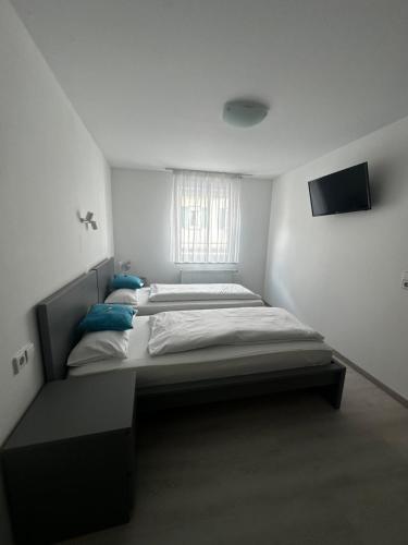 two beds in a small room with a window at Metzgerei Herbst in Besigheim