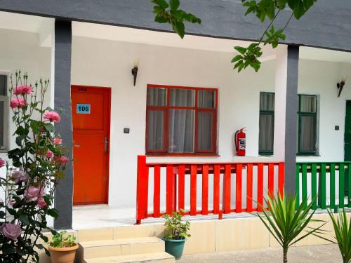 a red front door of a house with plants at Ones Pansiyon in Kumluca
