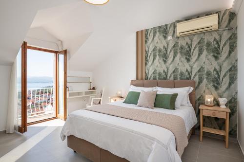 a bedroom with a large bed and a balcony at Apartments Micika in Cavtat
