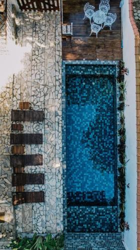 a wall with a swimming pool in a yard at Casas do Luiz Miguel in Caraguatatuba