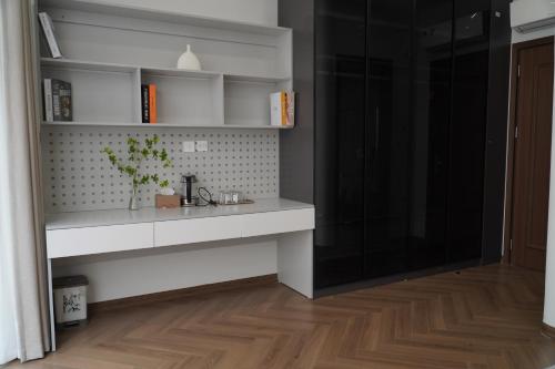 a kitchen with a white counter and a wooden floor at Vibe Home Vinhomes Ocean Park 2 in Hòa Bình