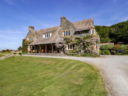a large house with a large grass yard at Plas Gwynfryn in Llanbedr