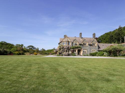 an old house with a large grass field at Plas Gwynfryn in Llanbedr