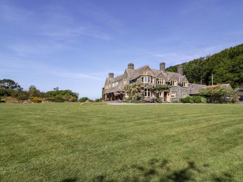 a large house with a large grass field at Plas Gwynfryn in Llanbedr