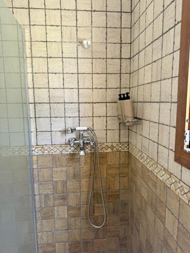 a shower with a hose in a tiled bathroom at Agroturismo Sa Marina - Adults Only in Cala Boix