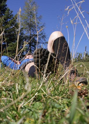 a person laying on the ground in the grass at Beste Aussicht ins Bergparadies in Eisenerz