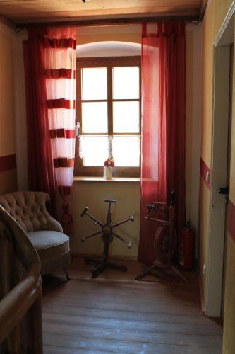 a living room with red curtains and a window at Landhotel Kahrmühle in Pressath