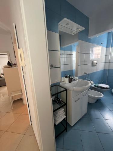 a blue and white bathroom with a sink and a toilet at Apartment Alexis Stefanos in Himare