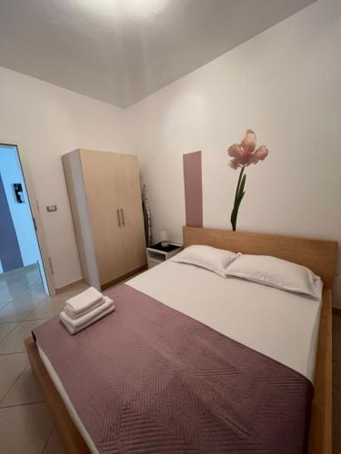 a bedroom with a bed with a flower on the wall at Apartment Alexis Stefanos in Himare