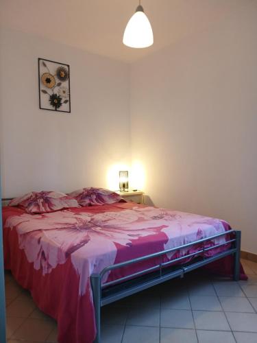 a bedroom with a bed with a pink blanket at gîte in Malafretaz