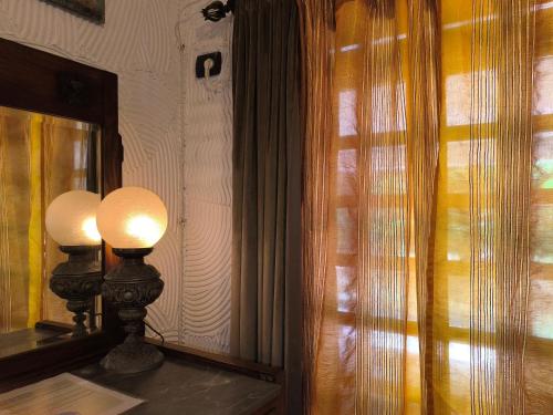 two lamps sitting on a table next to a window at Tamerici House in Montecastrilli