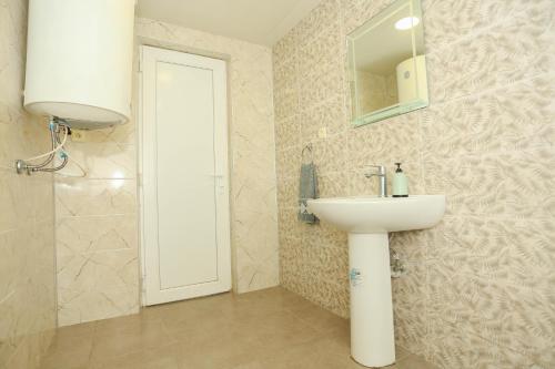a bathroom with a sink and a mirror at Qiwi House in Ureki