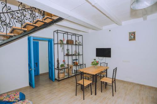 a dining room with a table and chairs and a staircase at Qiwi House in Ureki