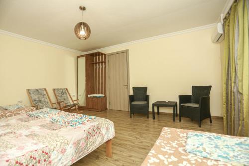 a bedroom with two beds and chairs and a table at Qiwi House in Ureki
