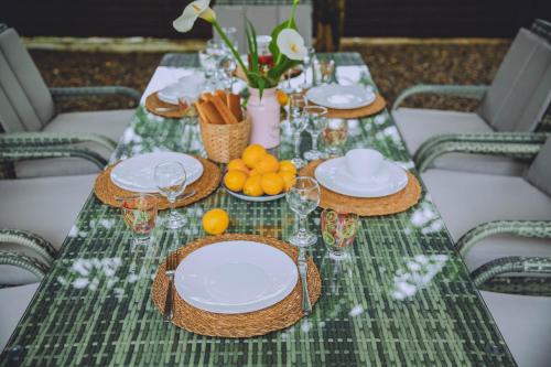 a table with plates and bowls of fruit on it at Qiwi House in Ureki
