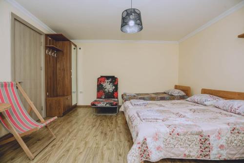 a bedroom with a bed and a chair at Qiwi House in Ureki