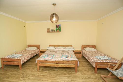 a room with three beds and a pendant light at Qiwi House in Ureki