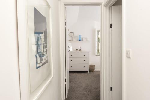een witte hal met een dressoir en een spiegel bij Piskey Cottage, Mousehole - Close to Harbourside - Free WiFi - Free Parking in Mousehole