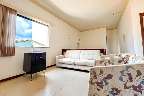 ein Wohnzimmer mit einer Couch und einem Fenster in der Unterkunft Casa 5/4 Atalaia a 200m da Passarela do Caranguejo in Santa Maria