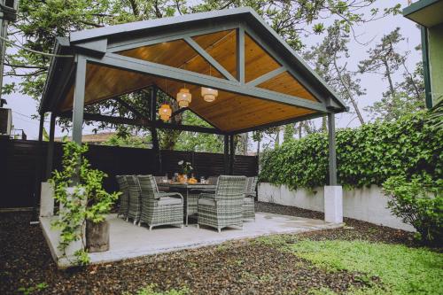 a gazebo with a table and chairs under it at Qiwi House in Ureki