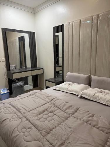a bedroom with a large bed and a mirror at hajer221 in Al Hofuf