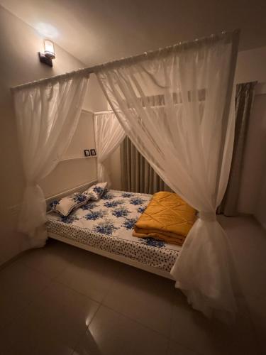 a small bed with a canopy in a room at Rosho homes in Pirangut